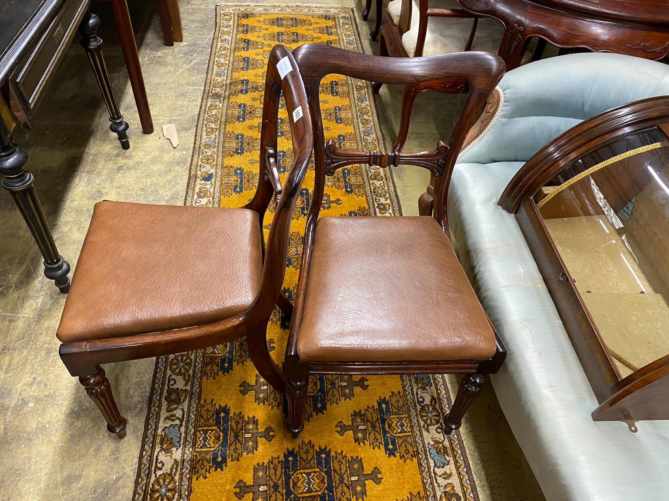 A set of four early Victorian rosewood dining chairs with drop in faux leather seats